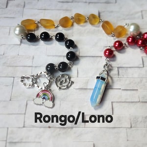 May include: A beaded necklace featuring black, red, yellow, and white beads. The necklace includes a rainbow charm, a spiral charm, and a blue and white crystal pendant. The text "Rongo/Lono" is displayed at the bottom.