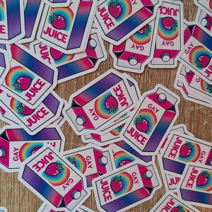 Puede incluir: Una colecci&oacute;n de pegatinas coloridas con una ilustraci&oacute;n de dibujos animados de una caja de jugo con un arco&iacute;ris y las palabras "GAY JUICE".