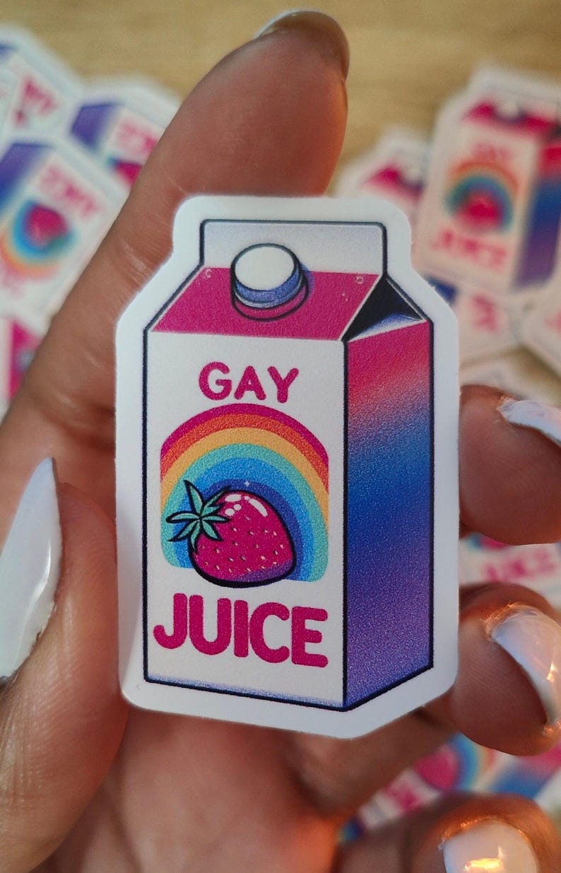 Puede incluir: Un cart&oacute;n blanco con un dise&ntilde;o degradado rosa, azul y morado. El cart&oacute;n tiene un arco&iacute;ris y una fresa en la parte delantera y las palabras "GAY JUICE" en letras rosas.