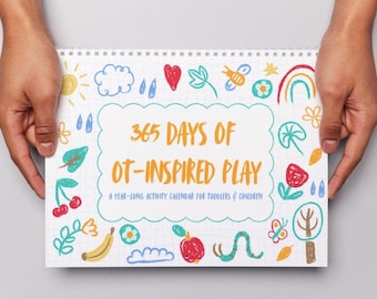 以下が含まれることがあります： 手で持たれた、カラフルなイラストと「365 DAYS OF OT-INSPIRED PLAY」の文字が入った、スパイラル綴じのカレンダー。幼児と子供向けの年間活動カレンダーです。