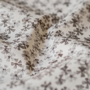 Peut inclure: Tissu blanc avec un motif discret de petites fleurs gris foncé.