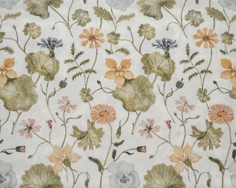 May include: A white fabric with a floral pattern. The flowers are in shades of blue, pink, and orange. The leaves are green.