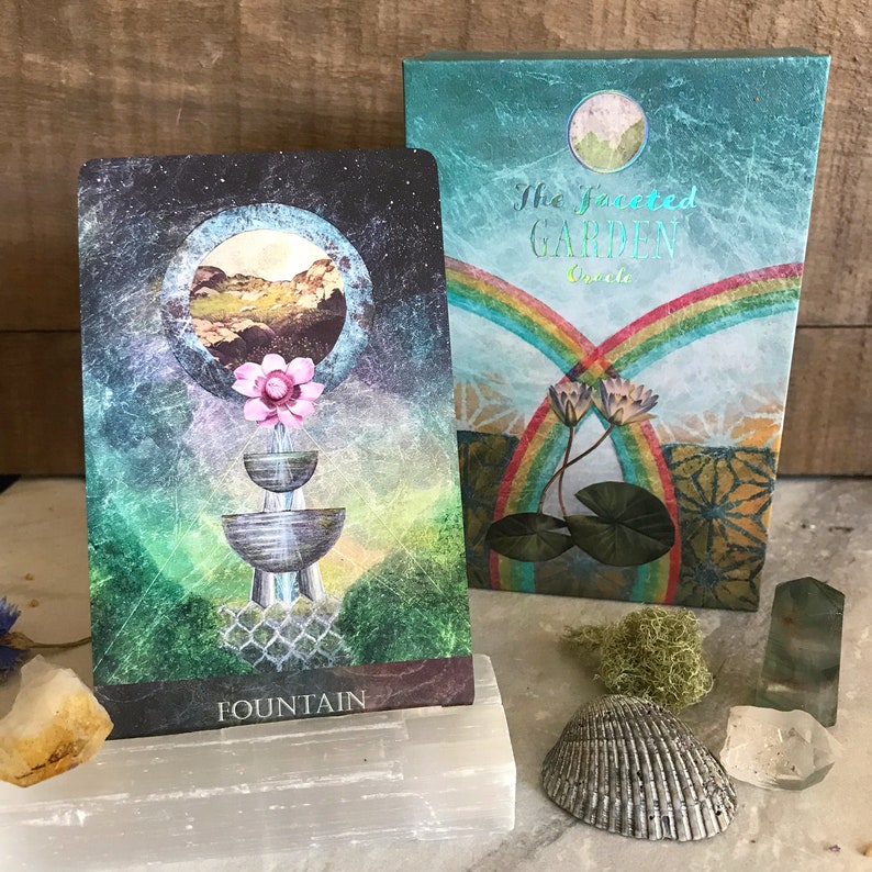 K&ouml;nnte beinhalten: Eine Karte aus dem "The Faceted Garden Oracle" Deck, mit einer stilisierten Illustration eines Brunnens mit einer rosa Blume oben. Die Karte ist mit "Fountain" betitelt.