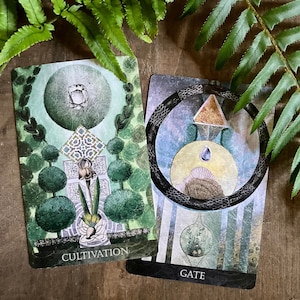 K&ouml;nnte beinhalten: Zwei Tarotkarten mit gr&uuml;ner und blauer Bildsprache. Die Karte links hat einen gr&uuml;nen Hintergrund mit einem Kreis in der Mitte und dem Wort "Cultivation" unten. Die Karte rechts hat einen blauen Hintergrund mit einem schlangenartigen Symbol in der Mitte und dem Wort "Gate" unten.