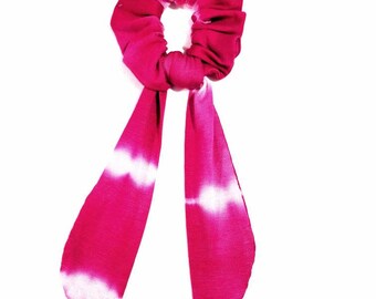 May include: A pink and white tie-dye scrunchie with a long, matching tie.
