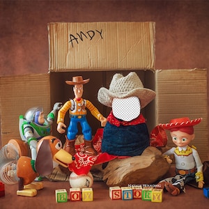 May include: Toy Story characters, including Woody, Buzz Lightyear, and Jessie, are arranged inside a cardboard box labeled "ANDY". The box is surrounded by colorful building blocks and a wooden sign that reads "BOY STORY".