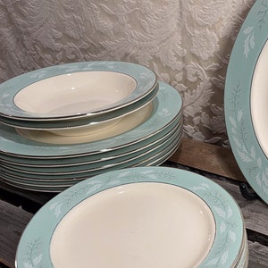 May include: A stack of vintage blue and white ceramic dinner plates with a delicate floral pattern. The plates are in excellent condition and would be a beautiful addition to any kitchen.