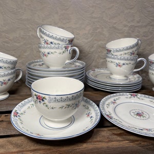 May include: A set of vintage teacups and saucers with a floral pattern in shades of blue, pink, and green. The cups and saucers have a delicate, feminine design and are perfect for a tea party or afternoon tea.