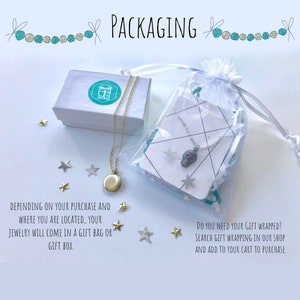 May include: A white gift box with a blue logo and a gold chain necklace with a round pendant. The necklace is packaged in a clear plastic bag with a white card and a silver chain necklace with a skull pendant. The text on the card reads "Do you need your gift wrapped? Search gift wrapping in our shop and add to your cart to purchase."