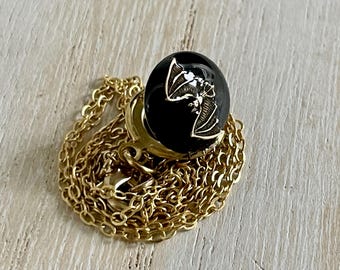 Black locket necklace with flying bat