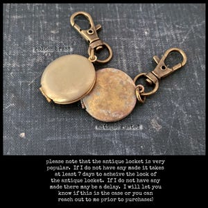 May include: A gold locket keychain with a golden brass finish and an antique rusted finish. The locket is open and the inside is visible. The keychain has two clasps. "Please note that the antique locket is very popular. If I do not have any made it takes at least 7 days to achieve the look of the antique locket. If I do not have any made there may be a delay. I will let you know if this is the case or you can reach out to me prior to purchase."