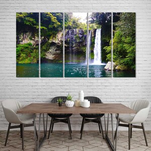 May include: A multi-panel canvas print featuring a waterfall cascading down a rocky cliff face, surrounded by lush green foliage. The water flows into a clear blue pool at the base of the waterfall.