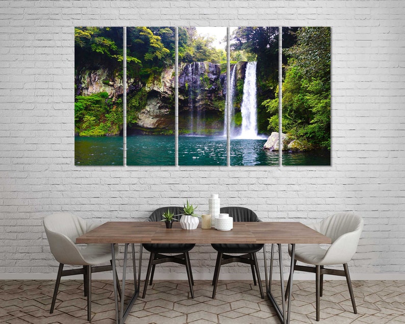 May include: A multi-panel canvas print featuring a waterfall cascading down a rocky cliff face, surrounded by lush green foliage. The water flows into a clear blue pool at the base of the waterfall.
