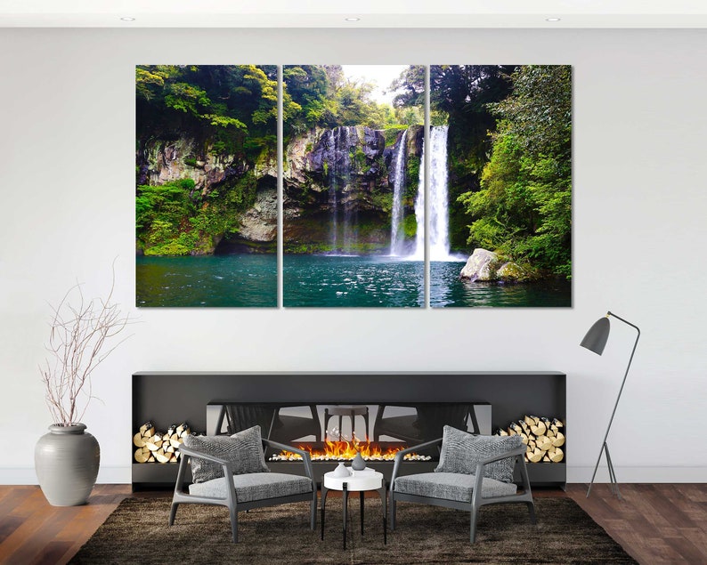 May include: A three-panel canvas print featuring a waterfall cascading down a rocky cliff face, surrounded by lush green foliage. The water is clear and blue, and the surrounding vegetation is vibrant and verdant.