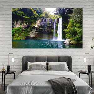 May include: A photograph of a waterfall cascading down a rocky cliff face, surrounded by lush green foliage. The water is clear and blue, and the surrounding vegetation is vibrant.