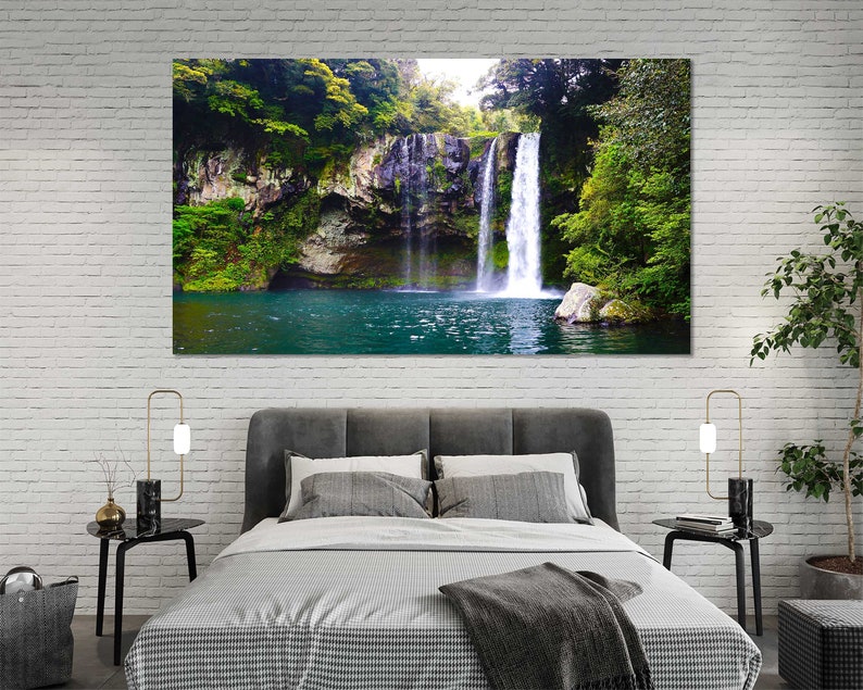 May include: A photograph of a waterfall cascading down a rocky cliff face, surrounded by lush green foliage. The water is clear and blue, and the surrounding vegetation is vibrant.