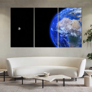 May include: A three-panel canvas print featuring a close-up of Earth with a small moon in the background. The Earth is shown in shades of blue and green, with clouds and landmasses visible. The moon is a small, white circle.
