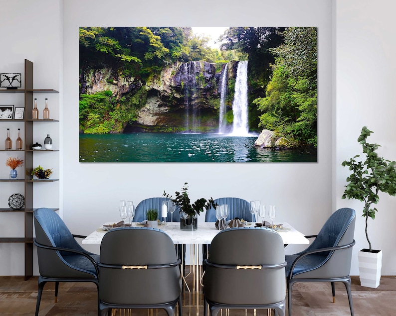 May include: A scenic photograph of a waterfall cascading down a rocky cliff face, surrounded by lush green foliage. The water is clear and blue, and the surrounding vegetation is vibrant and verdant.
