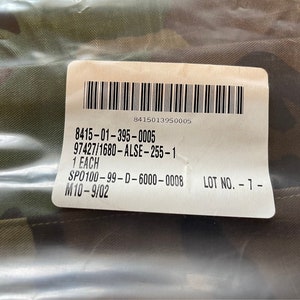 May include: A white label with black text and a barcode. The text reads: 8415-01-395-0005 97427/1680-ALSE-255-1 1 EACH SPO100-99-D-6000-0008 LOT NO.-7- M10-9/02