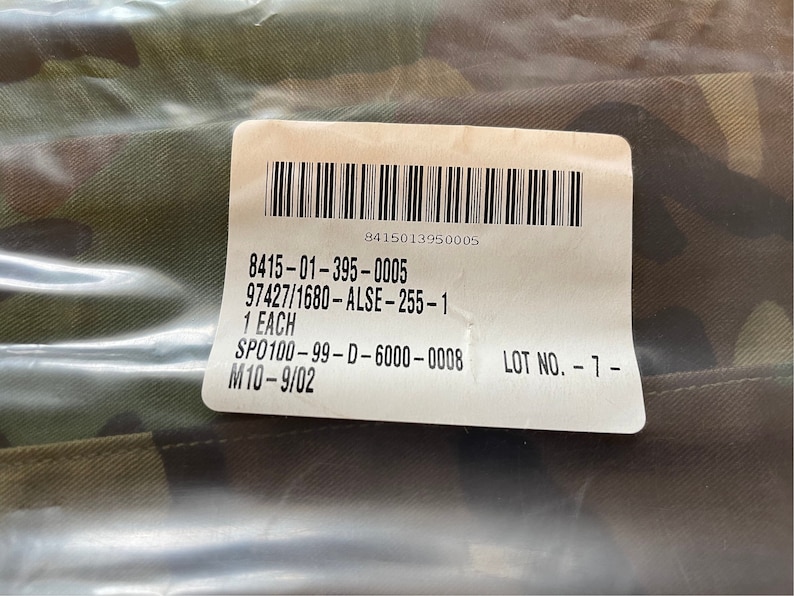 May include: A white label with black text and a barcode. The text reads: 8415-01-395-0005 97427/1680-ALSE-255-1 1 EACH SPO100-99-D-6000-0008 LOT NO.-7- M10-9/02