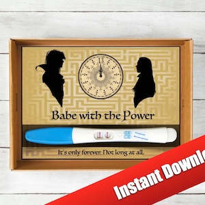 May include: A brown box with a pregnancy test inside. The box has a graphic of two silhouettes and a clock with the text "Babe with the Power" and "It's only forever. Not long at all."
