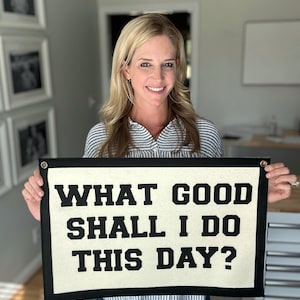 May include: A banner with the text "WHAT GOOD SHALL I DO THIS DAY?" in black block letters on an off-white background. The banner has a black border and grommets in the corners.