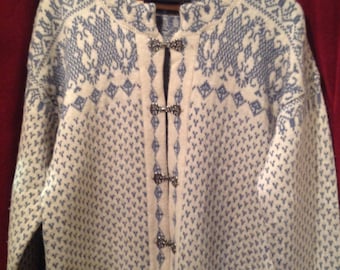 May include: White knitted cardigan with a blue patterned design and silver button closures.