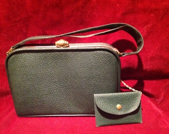 May include: A dark green leather purse with a gold clasp and a matching small coin purse attached to a gold chain.