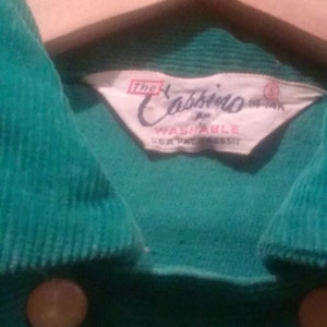 May include: A green corduroy shirt with a white label that reads "The Cabbieo Washable U.S.A. Pat. 185511".