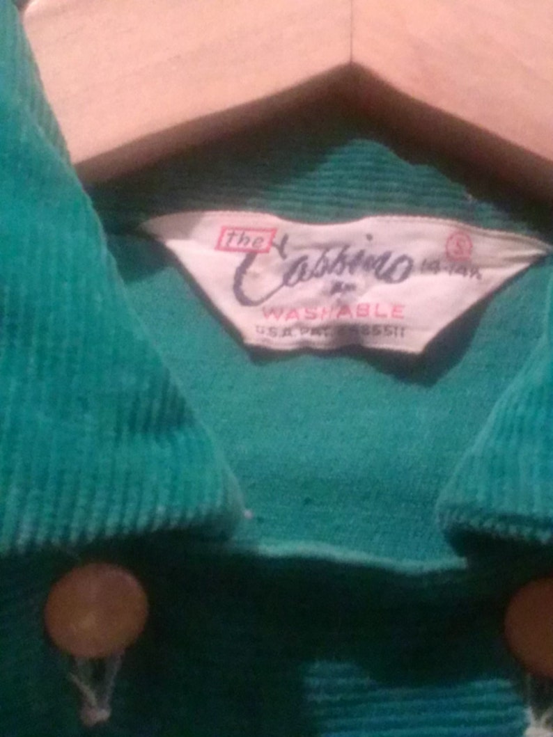 May include: A green corduroy shirt with a white label that reads "The Cabbieo Washable U.S.A. Pat. 185511".