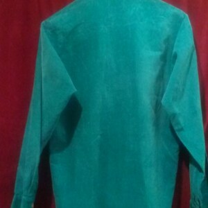May include: A teal long-sleeved shirt with a button-up collar.
