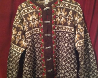 May include: A brown and white knitted cardigan with a geometric pattern and decorative metal buttons. The cardigan has a high neckline and long sleeves.
