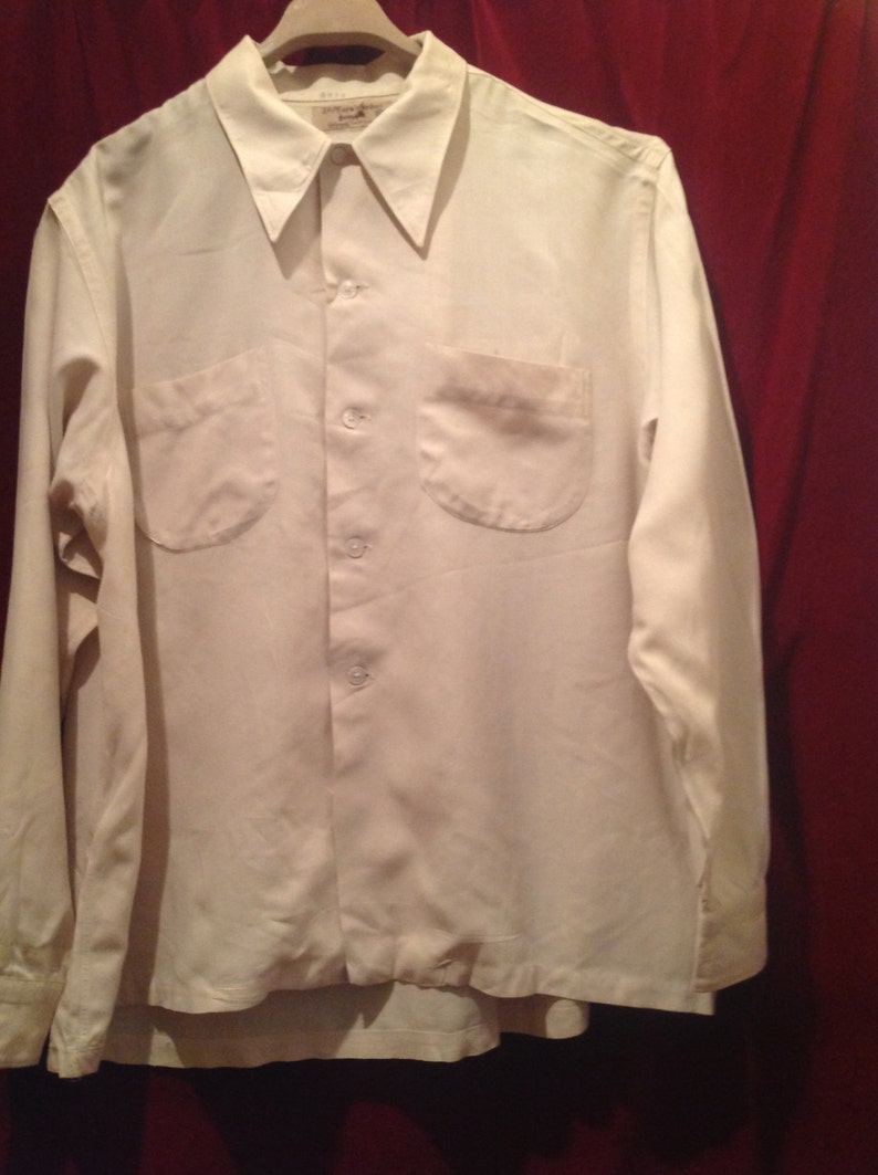 May include: A white long-sleeved button-down shirt with two chest pockets.