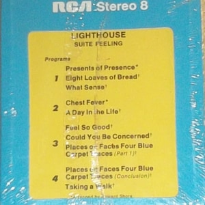 May include: A yellow and blue cassette tape case with the title "LIGHTHOUSE SUITE FEELING" and a list of songs: "Presents of Presence", "Eight Loaves of Bread", "What Sense", "Chest Fever", "A Day In the Life", "Feel So Good", "Could You Be Concerned", "Places or Faces Four Blue Carpet Races (Part 1)", "Places or Faces Four Blue Carpet Races (Conclusion)", and "Taking a Walk".