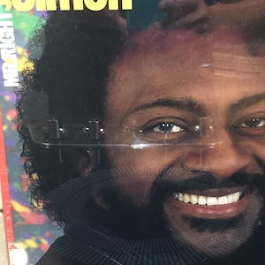 May include: Album cover featuring a smiling man with dark hair and a mustache. The text "JOE SIMON" is in large yellow letters at the top, with "MR. RIGHT" in white letters on the left side. The background has a colorful, blurred design.