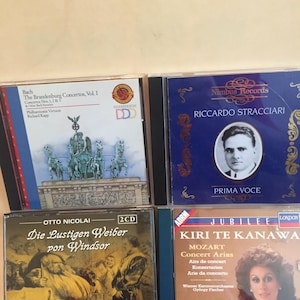 May include: A collection of classical music CDs. The CDs feature various artists and composers, including Bach, Mozart, and Riccardo Stracciari. The album covers display text and images related to the music.