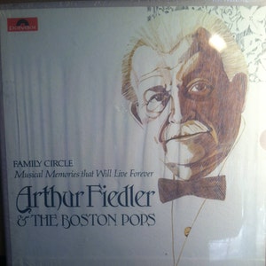 May include: A vintage record album cover featuring a black and white illustration of Arthur Fiedler, conductor of the Boston Pops Orchestra. The album title is "Family Circle: Musical Memories that Will Live Forever".