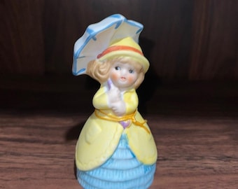 Abrigo amarillo y vestido azul con paraguas de la marca Vintage Adorabelles para niña, 1979.