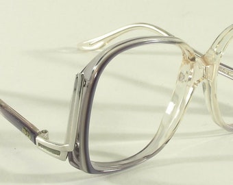 May include: A pair of clear plastic eyeglasses with a purple frame. The frame has a double rim design and the arms are silver.