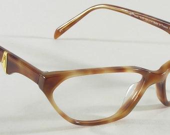 May include: Brown and tan cat-eye eyeglasses with a gold accent on the temples. The frames have a tortoiseshell pattern. The lenses are clear. The glasses are angled, showing the shape and design.