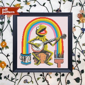 Peut inclure: Modèle de point de croix représentant Kermit la grenouille jouant du banjo devant un arc-en-ciel. Le motif comprend un pot de peinture et un pinceau.