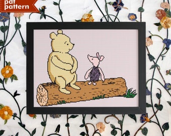 May include: A cross-stitch pattern featuring Winnie the Pooh and Piglet sitting on a log. The pattern is framed in a black frame and is set against a white background with floral vines.
