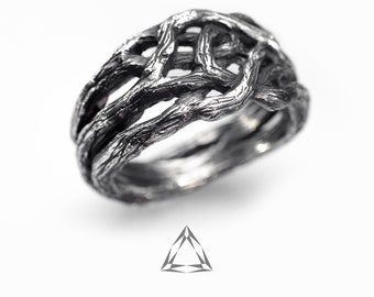 Può includere: Un anello d'argento con un design di rami intrecciati, creando un motivo testurizzato e intricato.