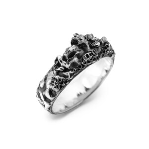 Puede incluir: Un anillo de plata con un dise&ntilde;o detallado y texturizado que presenta un patr&oacute;n floral org&aacute;nico en relieve.