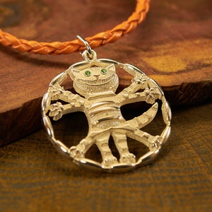 Peut inclure: Un collier avec un pendentif en argent repr&eacute;sentant un chat fantaisiste aux yeux verts et au corps ray&eacute;. Le chat est repr&eacute;sent&eacute; avec les bras et les jambes tendus, formant un cercle autour du pendentif.