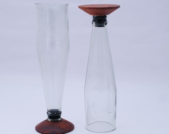 Vasos altos y transparentes hechos con botellas de cerveza Kingfisher y un símbolo de pájaro.