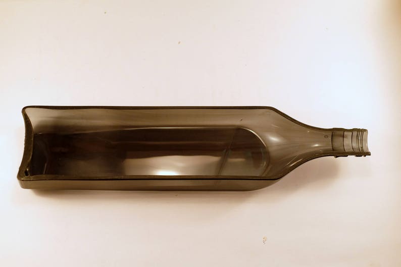 May include: A clear, plastic bottle shaped like a serving dish. The bottle is designed to hold and serve items like snacks or condiments.
