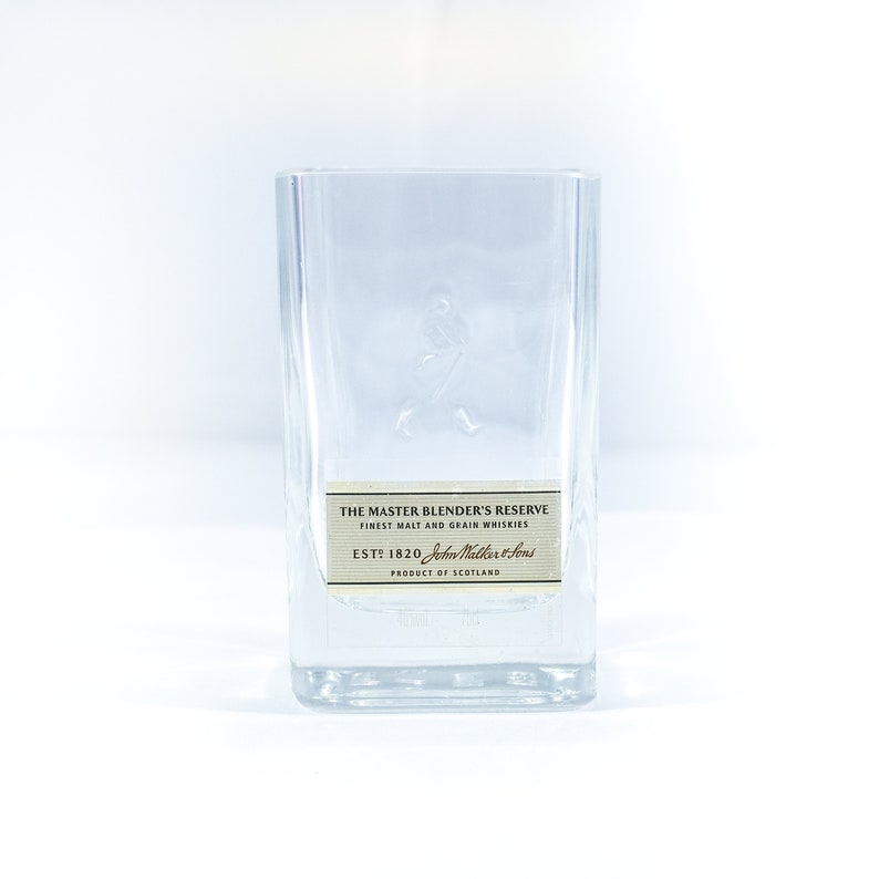May include: A clear glass bottle with a label that reads "The Master Blender's Reserve Finest Malt and Grain Whiskies Est: 1820 John Walker & Sons Product of Scotland".