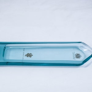 May include: A light blue glass tray with rounded edges and a raised lip. The tray has a clear centre and a light blue border. The text "ESTABLISHED 1881" is printed on the tray.