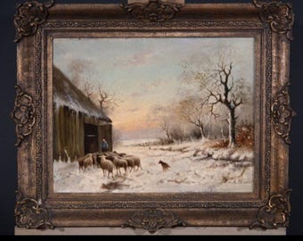 May include: An antique oil painting in a decorative gold frame depicts a winter landscape with a barn, sheep, and a dog in a snowy field. The artwork features a muted color palette with a sunset in the background.